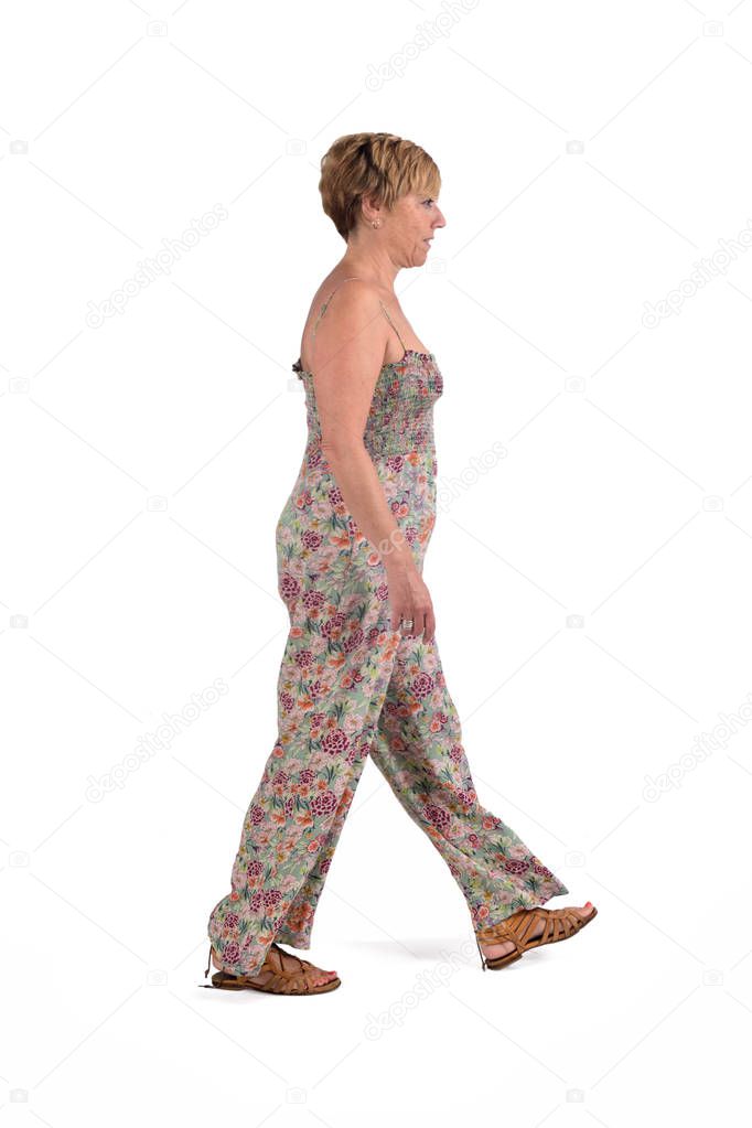 full portrait of middle aged woman walking on white