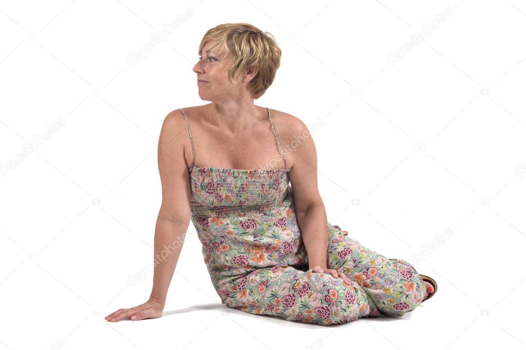 full portrait of middle aged woman sitting on the ground on white