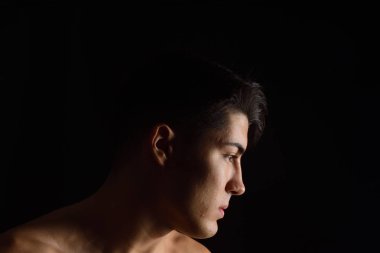 siyah arka plan üzerine genç bir adam portresi