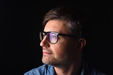 Siyah arka planda bir adamın portresi