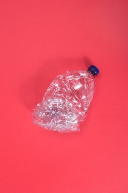 deforme plastik şişe kırmızı zemin üzerine
