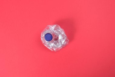 deforme plastik şişe kırmızı zemin üzerine