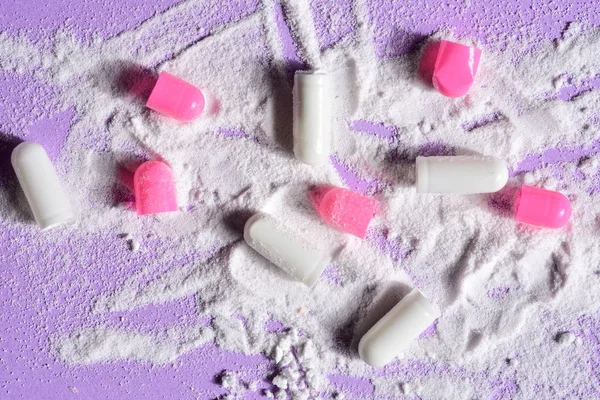 capsules pills broken with your powder medication on violet background