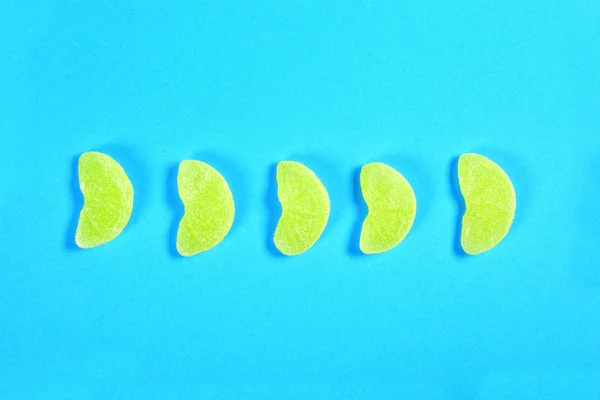 Група желе цукерки шматок апельсинових фруктів на синьому фоні — стокове фото