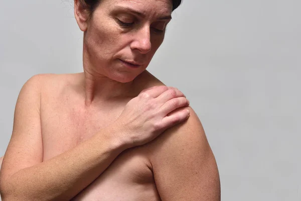 Middelbare leeftijd vrouw met pijn in de schouder — Stockfoto