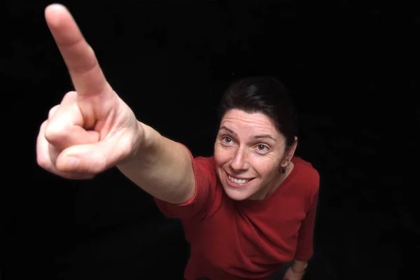 Woman pointing on black background — Stock Photo, Image