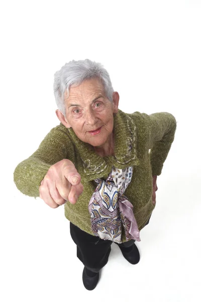 Seniorin zeigt auf weißen Hintergrund — Stockfoto
