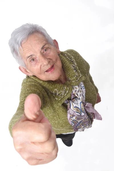 Seniorin mit Daumen hoch auf weiß — Stockfoto