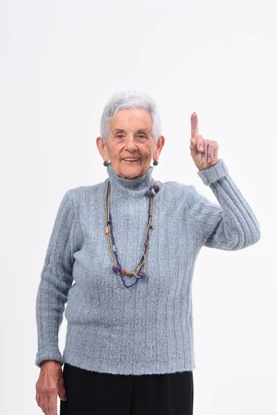 Пожилая женщина с пальцем в форме номера один — стоковое фото