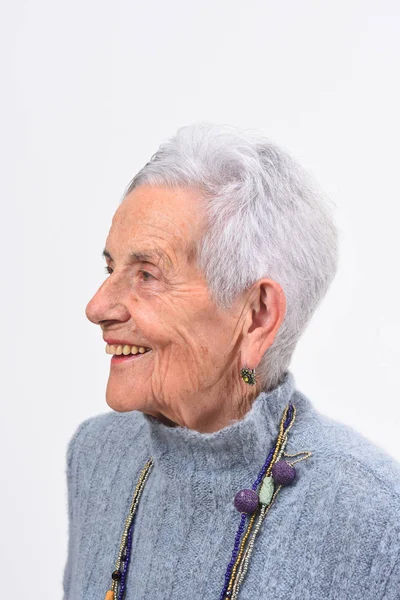 Портрет пожилой женщины, улыбающейся на белом фоне — стоковое фото