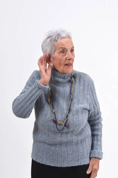 Senior kobieta kładąc rękę na jej do ucha, bo ona nie słyszy — Zdjęcie stockowe