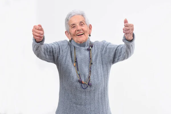 Äldre kvinna som vill ge dig en kram på vit bakgrund — Stockfoto