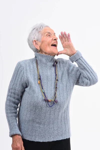Senior woman putting a hand in mouth and is screaming on white b — Stock Photo, Image