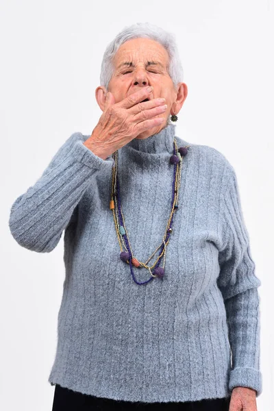 Seniorin gähnt auf weißem Hintergrund — Stockfoto