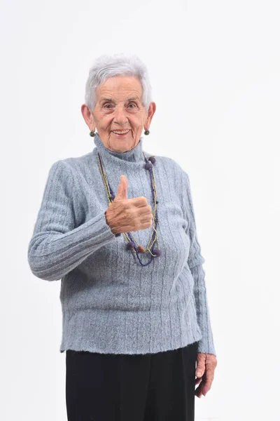 Senior woman thumps up on white background — Stock Photo, Image