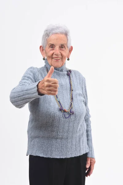 Ritratto di donna anziana con i pollici in su sul bianco — Foto Stock