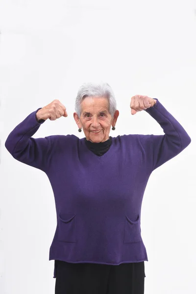 Senior femme faisant la force sur un fond blanc — Photo