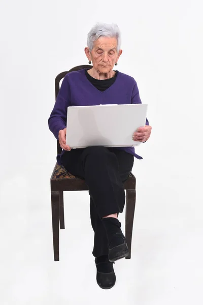 Senior vrouw met laptop op wit — Stockfoto