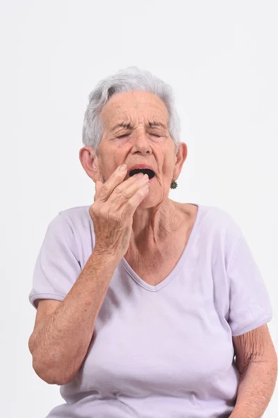 Старша жінка з болем на губі на білому тлі — стокове фото