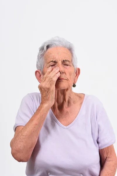 Senior kobieta z bólu na nos na białym tle — Zdjęcie stockowe