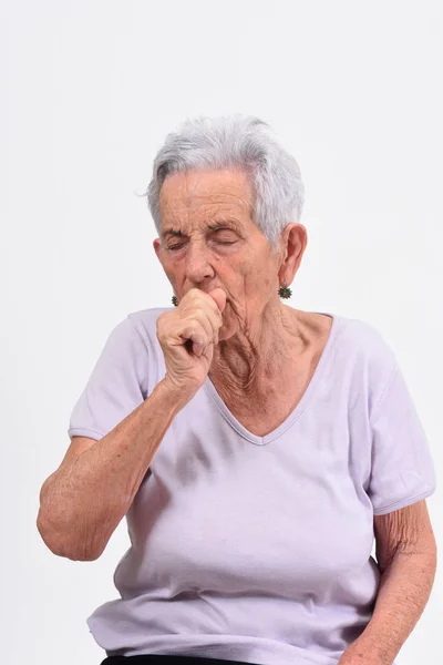 Senior vrouw met hoest op witte achtergrond — Stockfoto