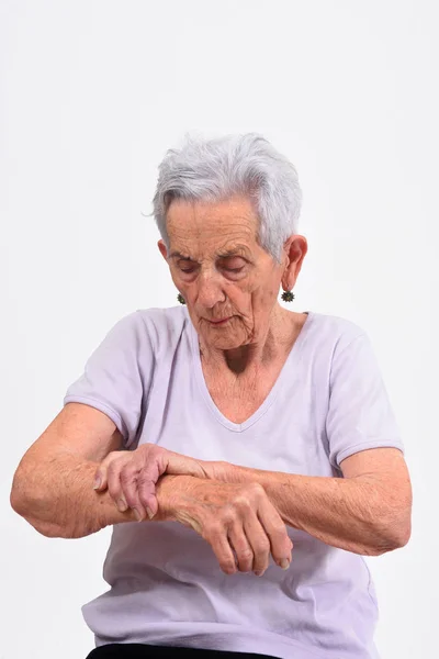 Senior vrouw met pijn aan de pols op witte achtergrond — Stockfoto