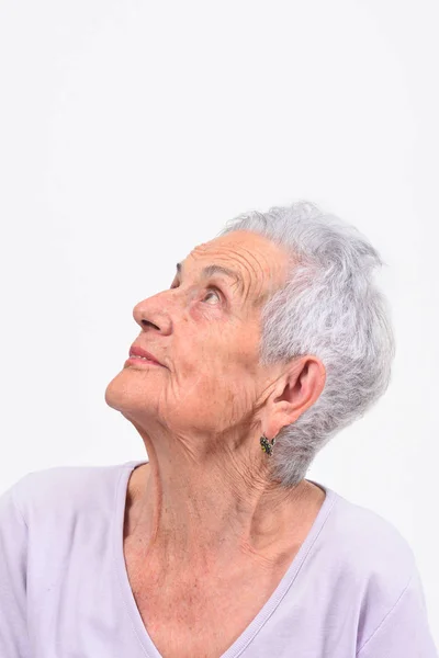 Portrait de femme âgée regardant vers le haut sur fond blanc — Photo