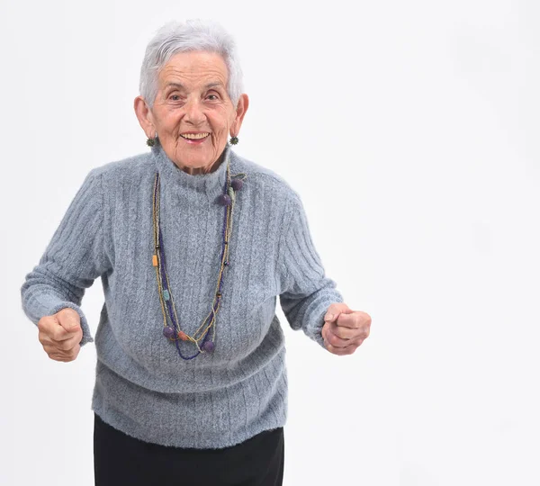 Senior kobieta podnoszenie jej ramiona i uśmiechając się w zwycięstwo Zarejestruj na whi — Zdjęcie stockowe