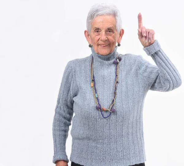 Starsza kobieta z palcem w kształcie numer jeden — Zdjęcie stockowe
