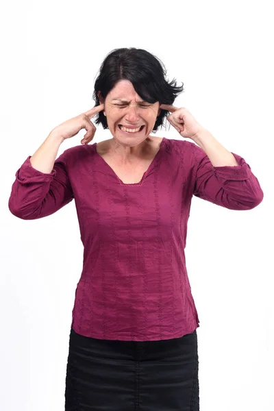 Kobieta robi hałas raniąc jej uszy na białym tle — Zdjęcie stockowe