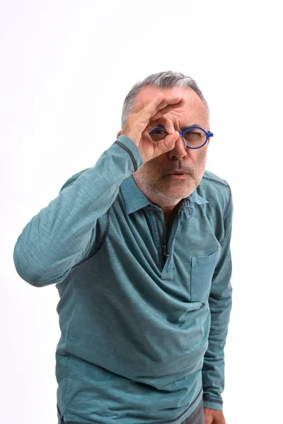 Hombre mirando a través de los dedos como si llevara gafas en el respaldo blanco —  Fotos de Stock