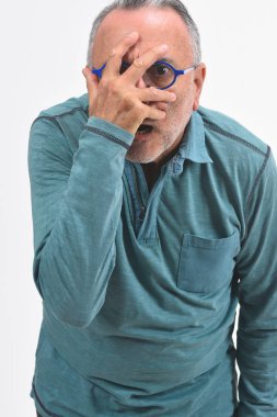 adam beyaz arka planda yüzüne el ile göz atma