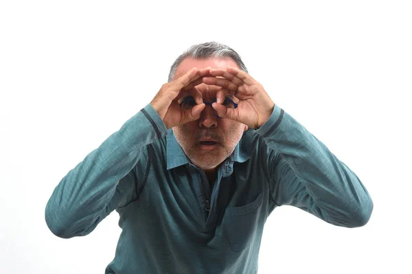 Hombre mirando a través de los dedos como si llevara gafas en el respaldo blanco —  Fotos de Stock