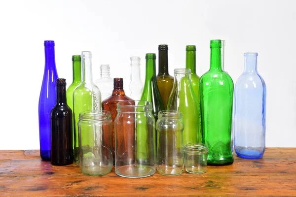 Group of bottles and glass jars on a wooden table with white bac — Stock Photo, Image