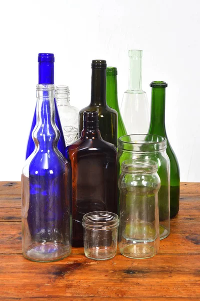 Group of bottles and glass jars on a wooden table with white bac — Stock Photo, Image