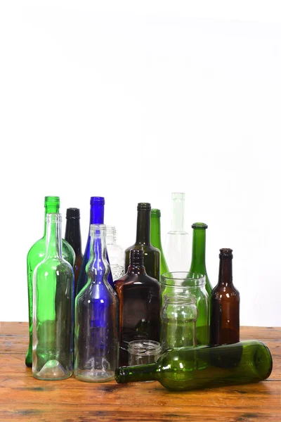 Grupp av flaskor och glasburkar på ett träbord med vit BAC — Stockfoto