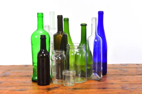 Grupp av flaskor och glasburkar på ett träbord med vit BAC — Stockfoto