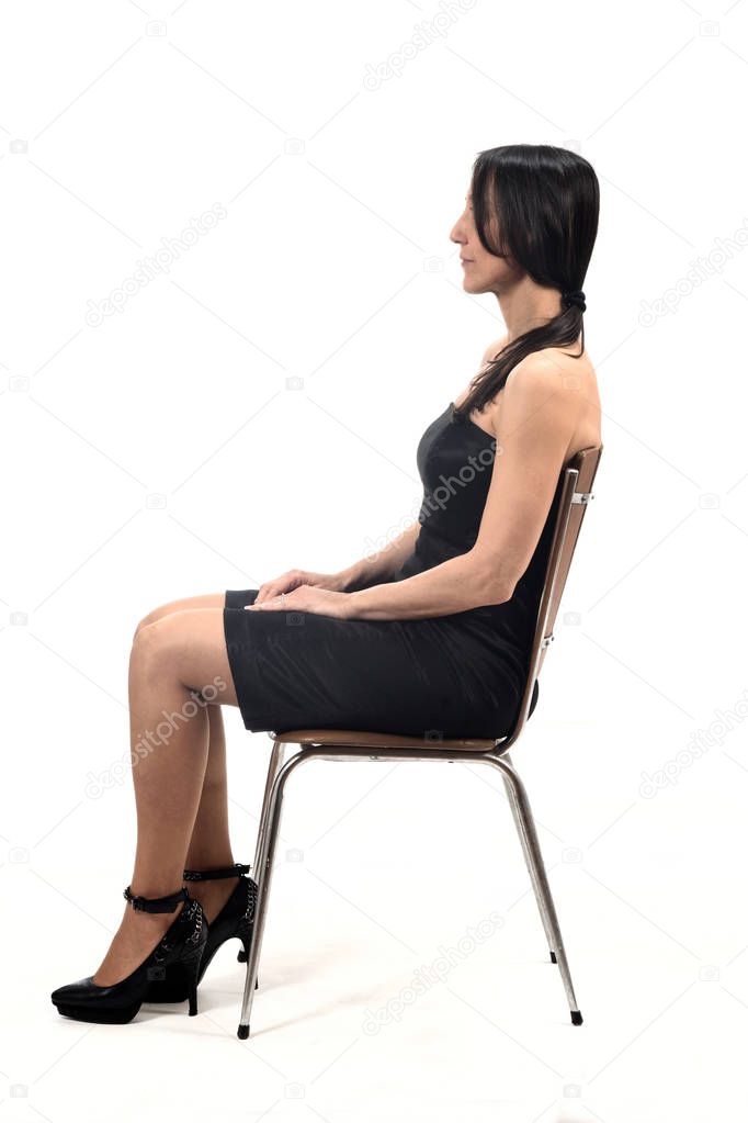 woman with off shoulder dress look side sitting on a chair isola