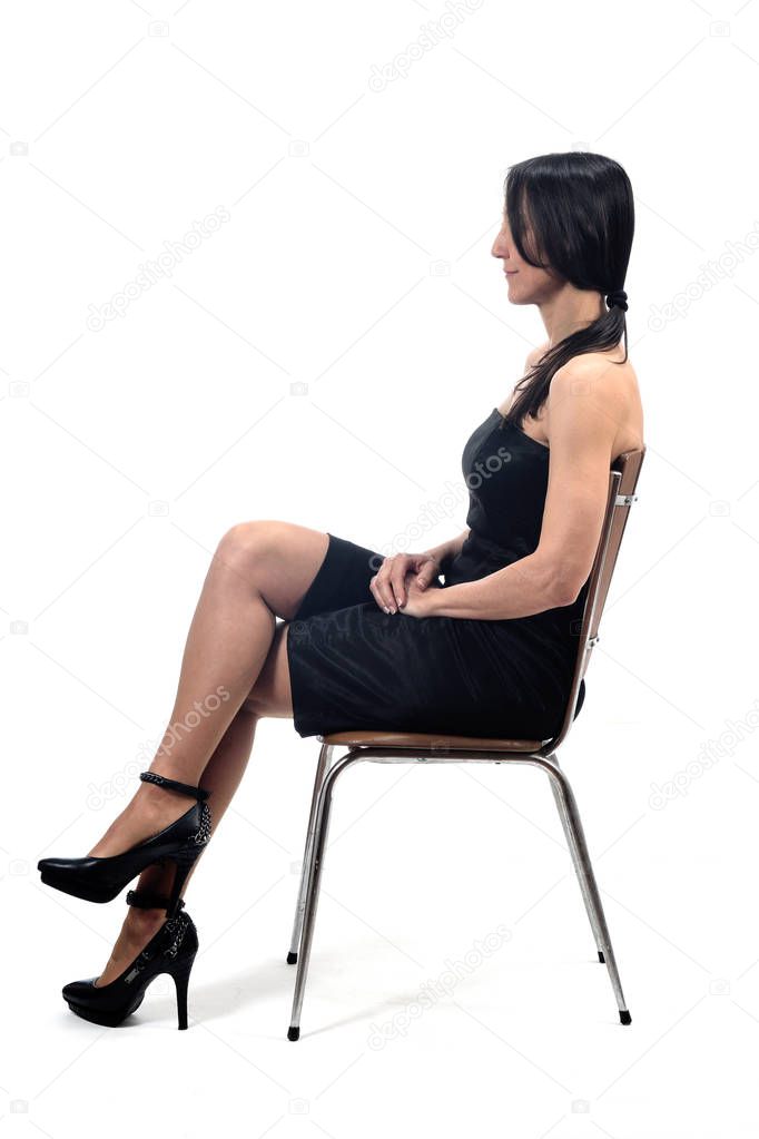 woman with off shoulder dress look side sitting on a chair isola