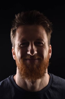 portrait of a smiling man on black background