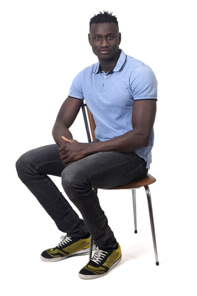 Full portrait of african man sitting a chair on white background