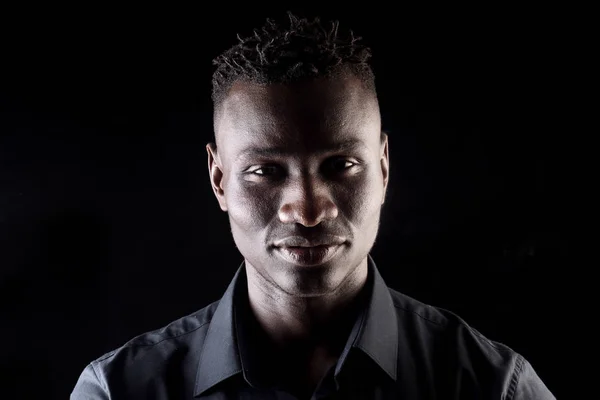 Retrato de um homem africano sobre fundo preto, grave — Fotografia de Stock