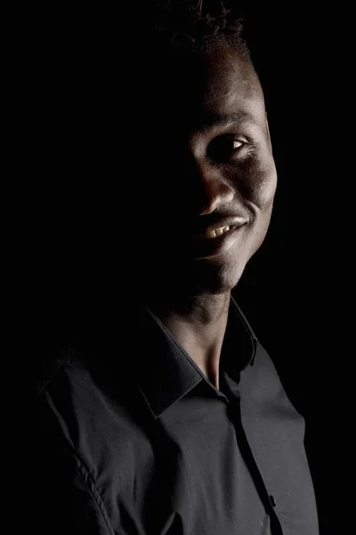 Retrato de um homem africano sobre fundo preto, sorrindo — Fotografia de Stock