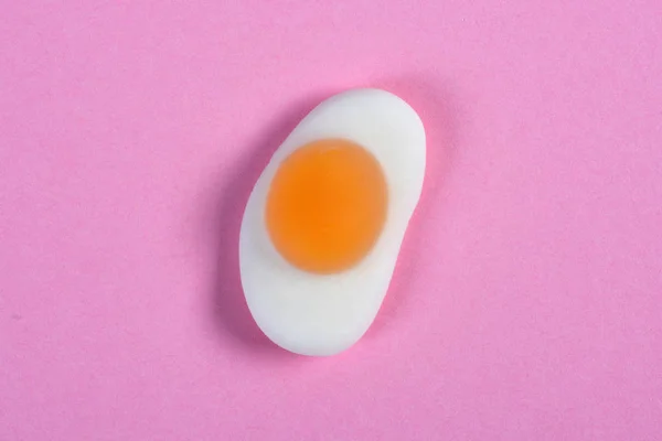 Galaretka cukierki smażone jajko na różowym tle — Zdjęcie stockowe