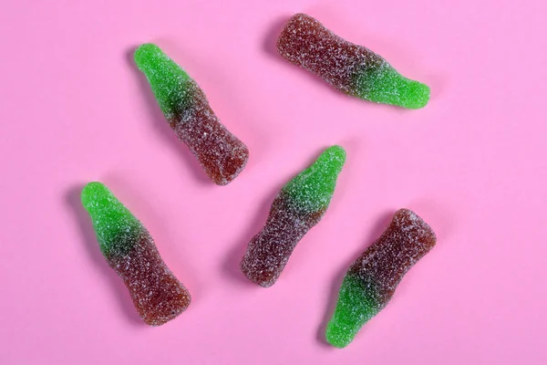 Grupo de caramelos de gelatina botellas de coque sobre fondo rosa — Foto de Stock