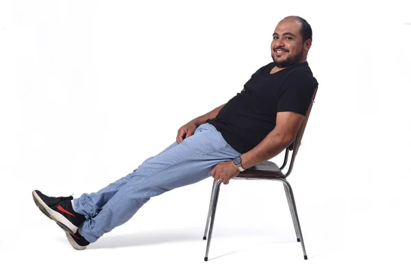 Full portrait of a south american  man sitting on a chair on whi — Stock Photo, Image