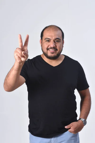 Hombre latino con el dedo en forma de número dos —  Fotos de Stock