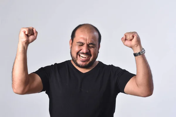 Latin Amerikalı adam kollarını yükseltmek ve zafer işareti gülümsüyor — Stok fotoğraf