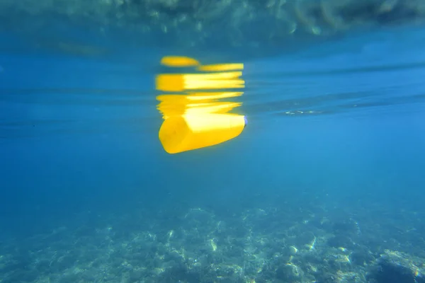 Una botella de detergente flotando en el mar — Foto de Stock