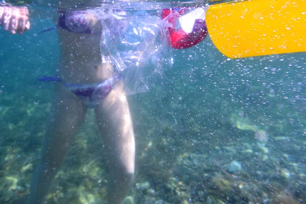 Kobieta w morzu otoczona plastikowymi śmieciami — Zdjęcie stockowe